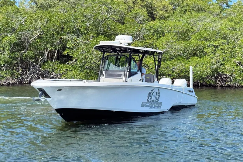 Slide: The Image of 2021 Wellcraft 302 Fisherman boat cruising on water near lush greenery. - 6