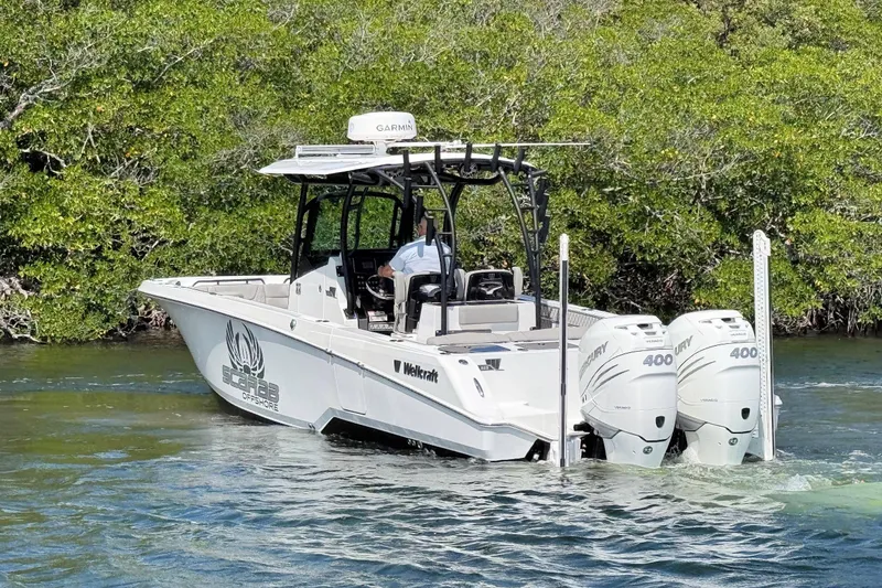 Slide: The Image of 2021 Wellcraft 302 Fisherman boat with twin Mercury 400 engines on a scenic waterway. - 8