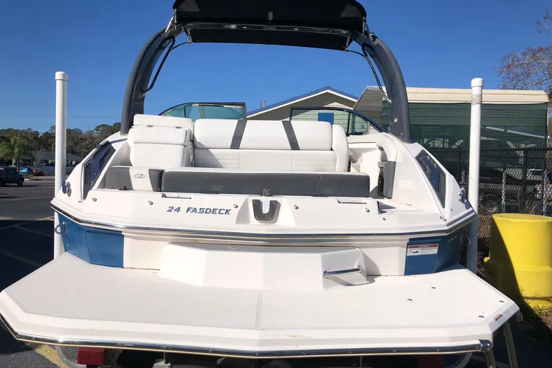 Slide: The Image of 2017 Regal 24 FasDeck boat with white seating and blue accents, parked outdoors. - 3