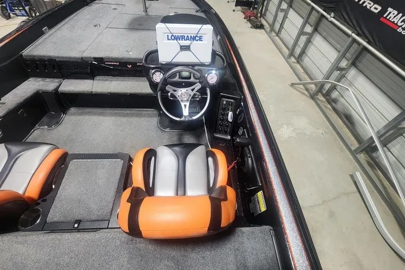 Slide: The Image of 2019 Phoenix 920 ProXP boat interior with Lowrance system and orange seats. - 2