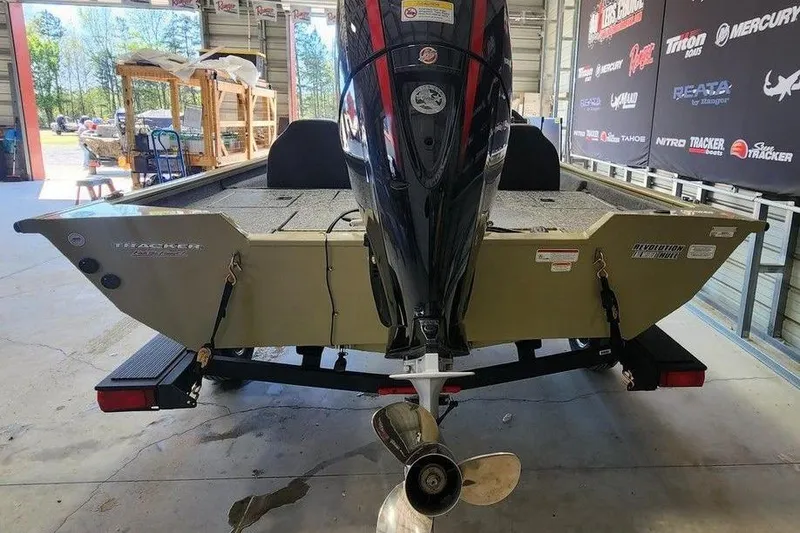 Slide: The Image of 2026 Tracker Pro Team 195 boat in showroom, rear view with motor and propeller. - 2