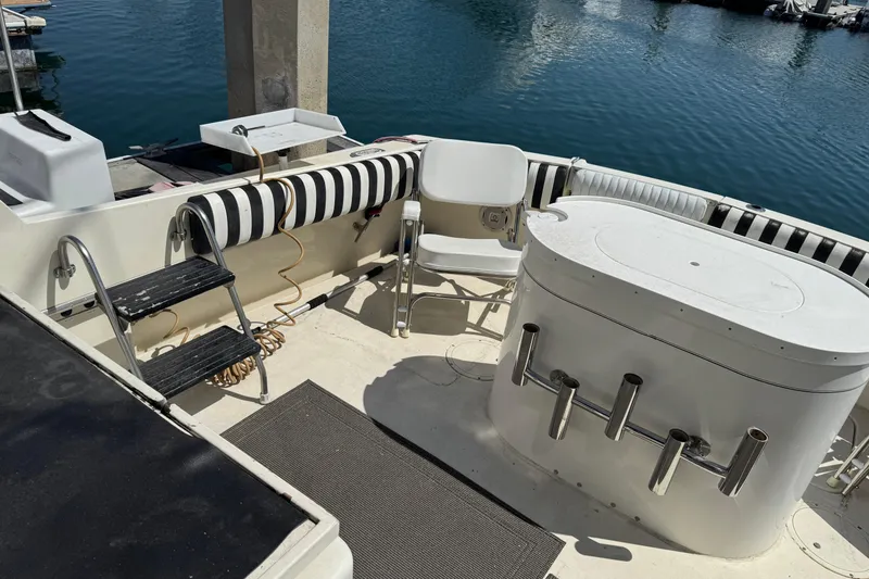 Slide: The Image of 1985 Hatteras 45 Convertible boat deck with seating and fishing rod holders. - 10