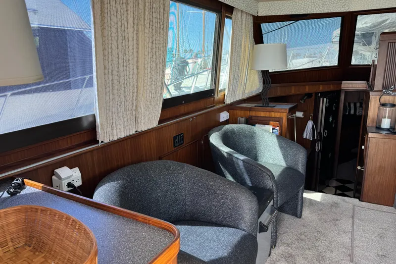 Slide: The Image of Interior of 1985 Hatteras 45 Convertible yacht with cozy seating and wooden accents. - 24