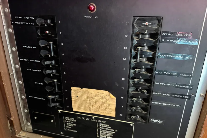 Slide: The Image of Electrical panel of a 1985 Hatteras 45 Convertible boat with labeled switches. - 26