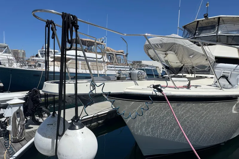 Slide: The Image of 1985 Hatteras 45 Convertible yacht docked at marina under clear blue sky. - 3