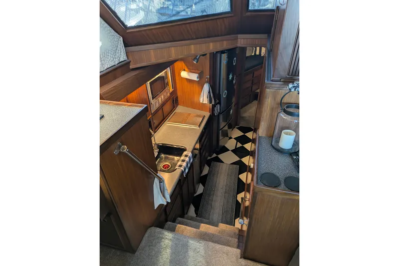 Slide: The Image of Interior of 1985 Hatteras 45 Convertible yacht, featuring a compact kitchen area. - 30