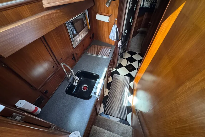 Slide: The Image of Interior of 1985 Hatteras 45 Convertible yacht kitchen with wood cabinetry and checkered floor. - 31