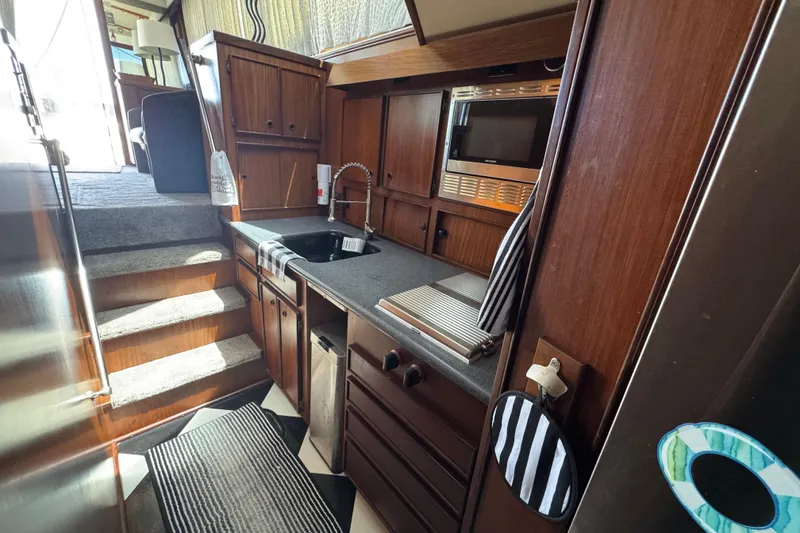 Slide: The Image of Interior of 1985 Hatteras 45 Convertible yacht kitchen with wood cabinetry and modern appliances. - 33