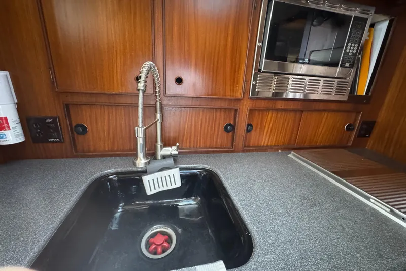 Slide: The Image of 1985 Hatteras 45 Convertible yacht kitchen with sink, faucet, and microwave. - 36