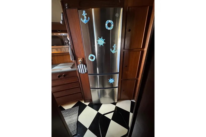 Slide: The Image of Nautical-themed kitchen in 1985 Hatteras 45 Convertible yacht with stainless steel fridge. - 40