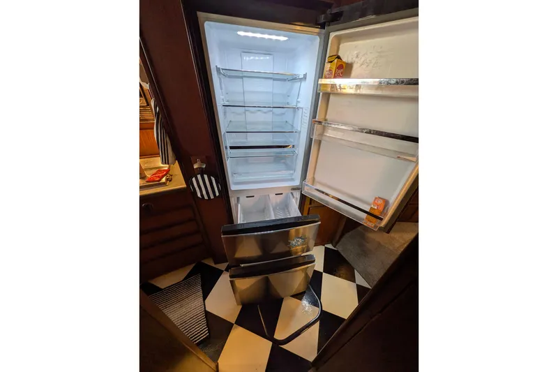 Slide: The Image of Open refrigerator inside 1985 Hatteras 45 Convertible yacht, showcasing spacious interior and modern design. - 41