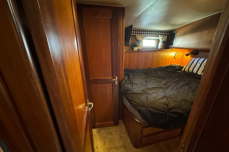 Slide: The Image of Cozy cabin interior of 1985 Hatteras 45 Convertible yacht with wood paneling and bed. - 43