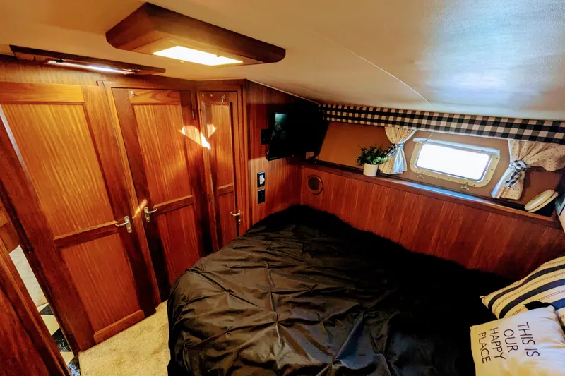 Slide: The Image of Cozy cabin interior of 1985 Hatteras 45 Convertible yacht with wood paneling and window. - 44