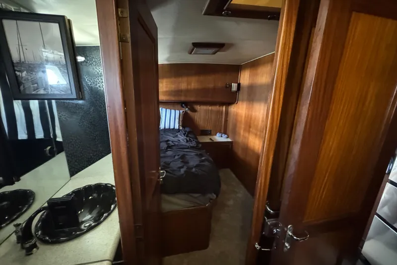 Slide: The Image of Interior of 1985 Hatteras 45 Convertible yacht, featuring cozy wood-paneled cabin and bathroom. - 48
