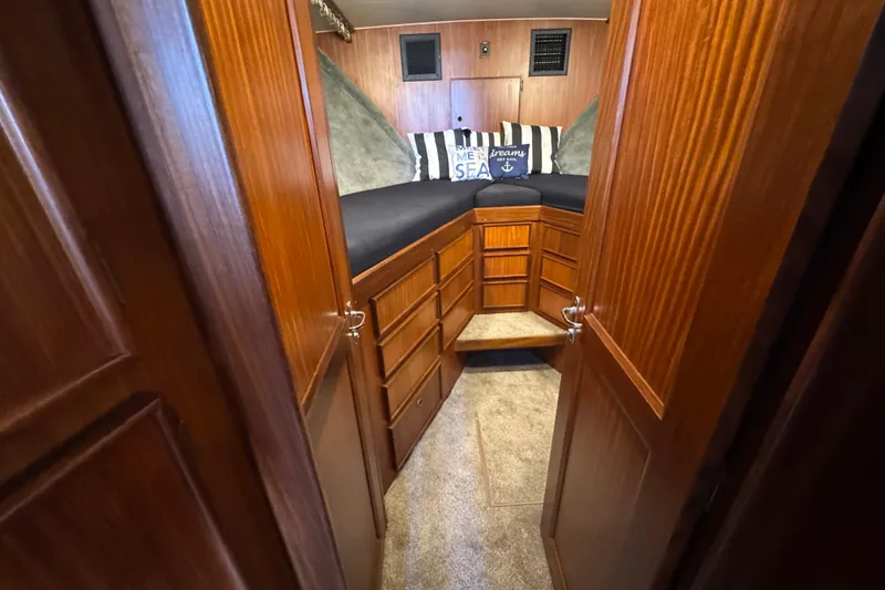 Slide: The Image of 1985 Hatteras 45 Convertible cabin interior with wood paneling and nautical-themed pillows. - 52