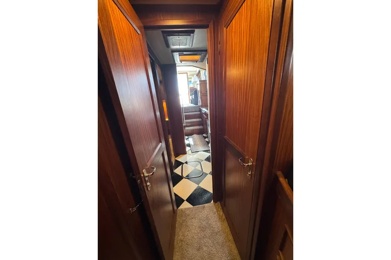 Slide: The Image of Interior hallway of 1985 Hatteras 45 Convertible yacht with wood paneling and checkered flooring. - 56