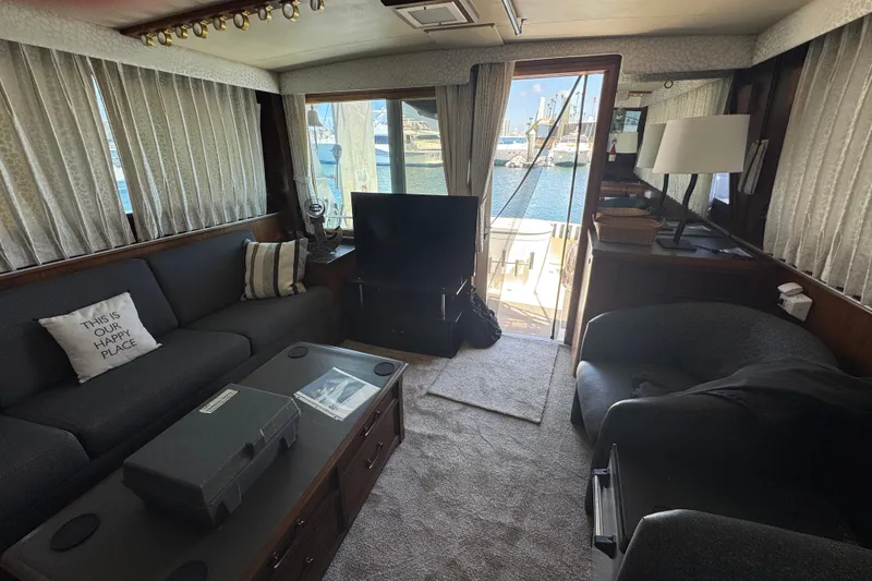 Slide: The Image of Interior of 1985 Hatteras 45 Convertible yacht with cozy seating and marina view. - 60