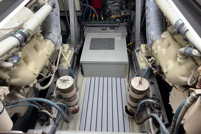Slide: The Image of Engine room of a 1985 Hatteras 45 Convertible yacht, showcasing dual engines and mechanical components. - 62