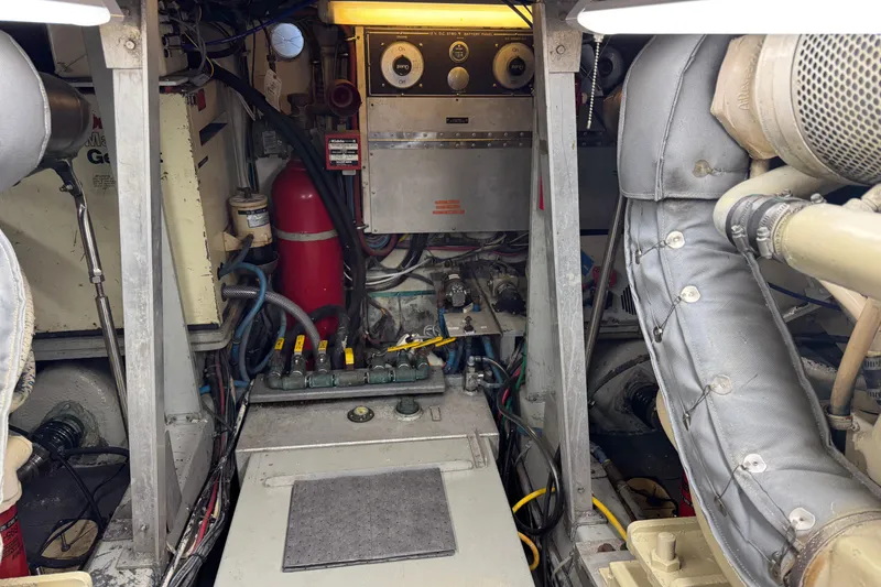 Slide: The Image of Engine room of a 1985 Hatteras 45 Convertible yacht, featuring mechanical components and wiring. - 65