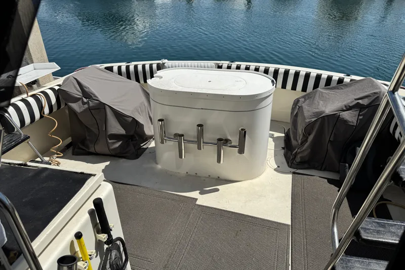 Slide: The Image of 1985 Hatteras 45 Convertible boat deck with covered seating and fishing rod holders. - 7