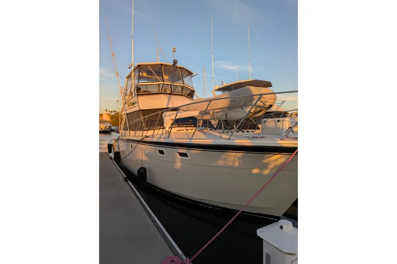Slide: The Image of 1985 Hatteras 45 Convertible yacht docked at sunset, showcasing sleek design and structure. - 70