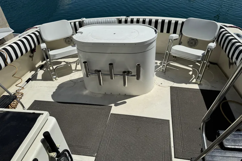 Slide: The Image of 1985 Hatteras 45 Convertible boat deck with seating and fishing rod holders. - 8
