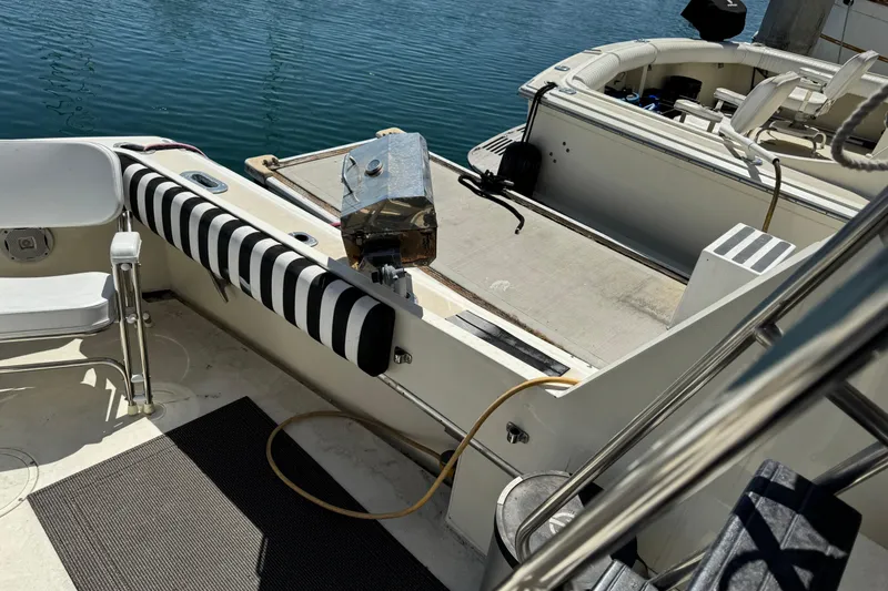 Slide: The Image of 1985 Hatteras 45 Convertible yacht deck with striped padding and seating by the water. - 9