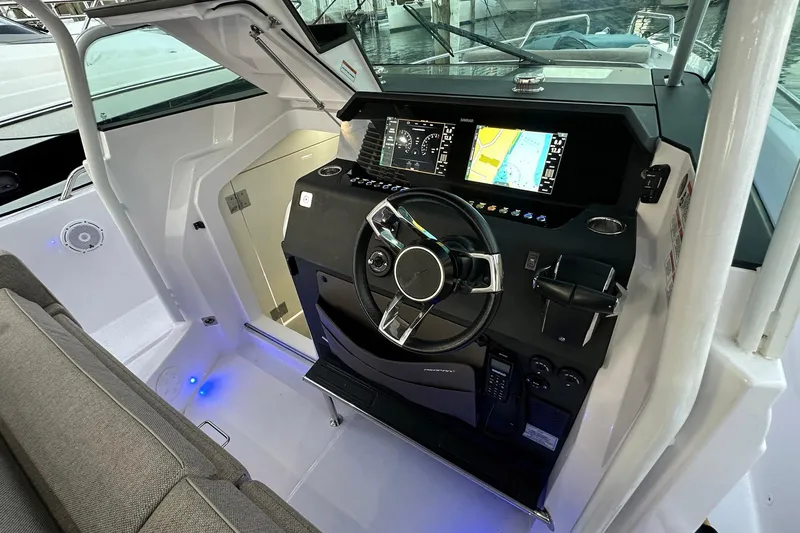 Slide: The Image of 2024 Axopar 37 Sun-Top helm with modern navigation displays and sleek steering wheel. - 14