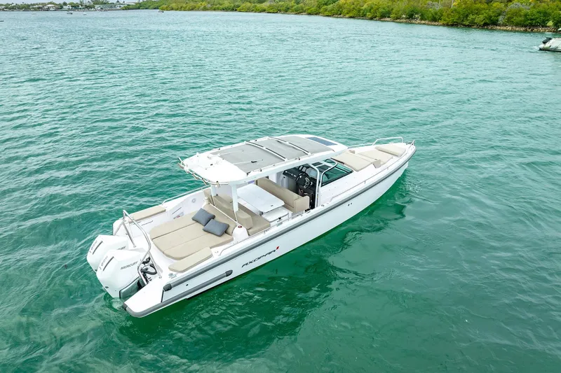 Slide: The Image of 2024 Axopar 37 Sun-Top boat cruising on clear turquoise water. - 7