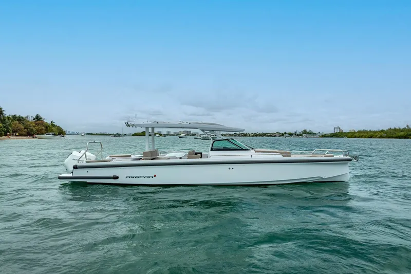 Slide: The Image of 2024 Axopar 37 Sun-Top boat on calm water, showcasing sleek design and modern features. - 8