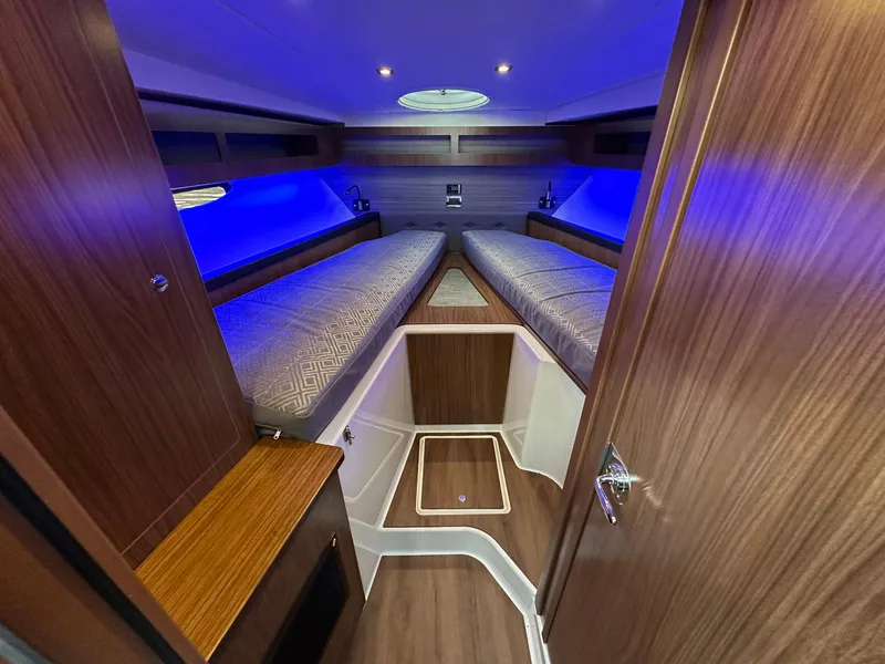 Slide: The Image of 2020 Four Winns Vista 355 Coupe interior with blue lighting and wooden finishes. - 13