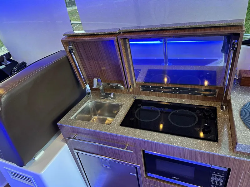 Slide: The Image of 2020 Four Winns Vista 355 Coupe kitchen with sink, stove, and microwave. - 30