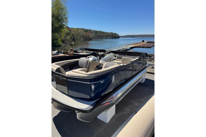 Slide: The Image of 2026 Harris Sunliner 210 pontoon boat docked by a serene lake. - 21
