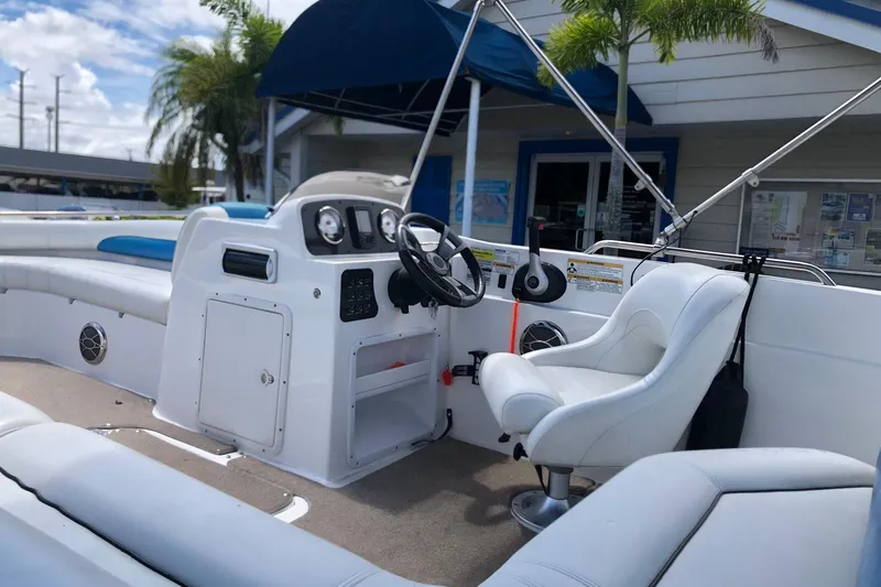 Slide: The Image of 2014 Hurricane SunDeck Sport 201 IO boat interior with steering wheel and seating. - 13