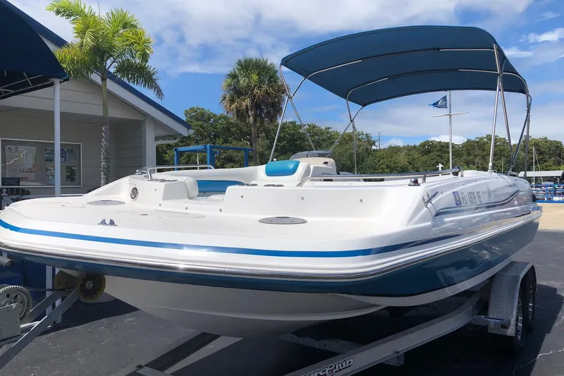 Slide: The Image of 2014 Hurricane SunDeck Sport 201 IO boat with canopy on trailer, parked outdoors. - 20