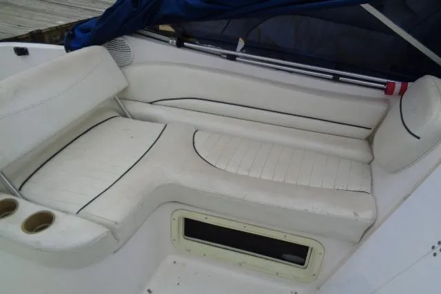 Slide: The Image of 2000 Bayliner 2455 Ciera Sunbridge interior seating with white upholstery and cup holders. - 16
