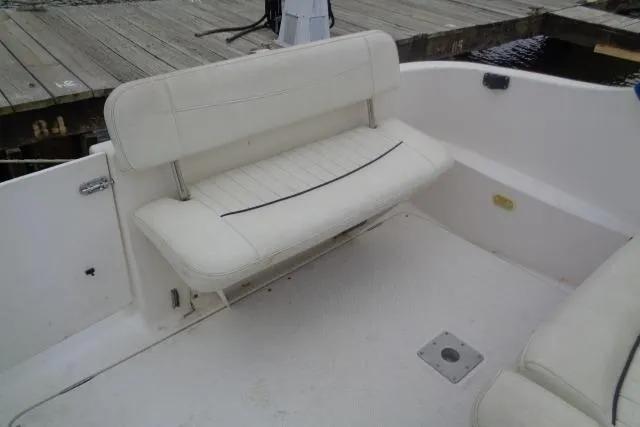 Slide: The Image of 2000 Bayliner 2455 Ciera Sunbridge boat interior with white seating near dock. - 19