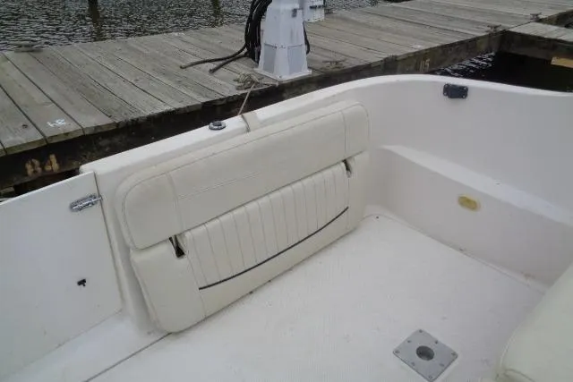Slide: The Image of 2000 Bayliner 2455 Ciera Sunbridge boat interior with white seating near dock. - 21