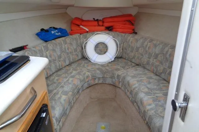 Slide: The Image of Interior of 2000 Bayliner 2455 Ciera Sunbridge with seating, life jackets, and a life preserver. - 24