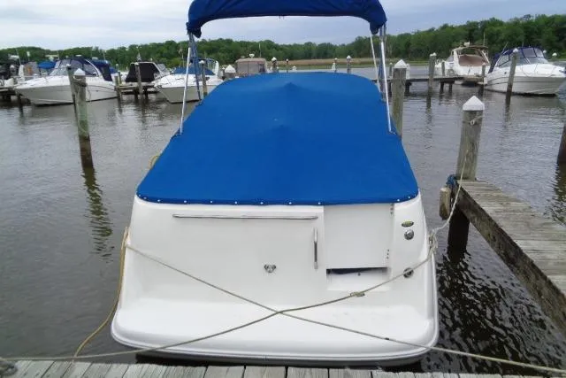 Slide: The Image of Bayliner 2455 Ciera Sunbridge 2000 docked with blue cover, marina background. - 9