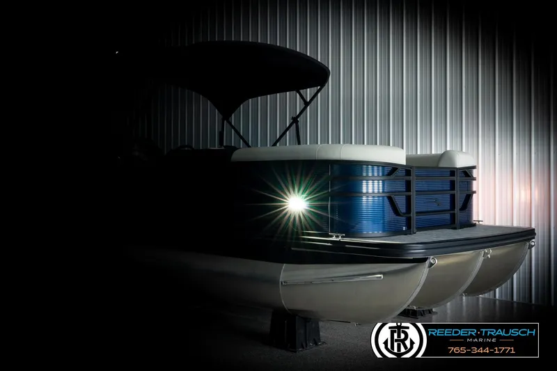 Slide: The Image of 2026 Bennington 22 SSBSF pontoon boat with illuminated bow, showcased in a dimly lit setting. - 4