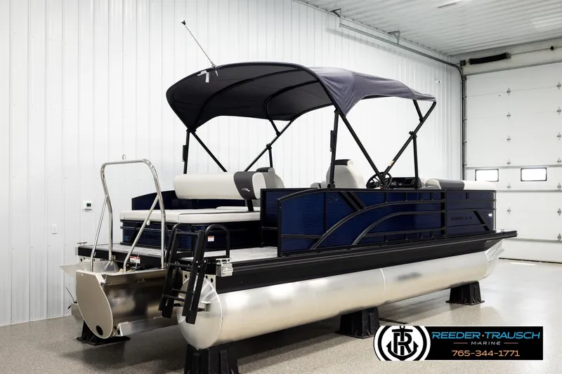 Slide: The Image of 2026 Bennington 22 SSBSF pontoon boat in a showroom with canopy and seating. - 6