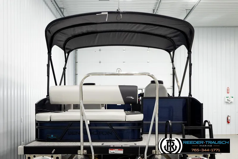 Slide: The Image of 2026 Bennington 22 SSBSF pontoon boat in a showroom with canopy and seating. - 7