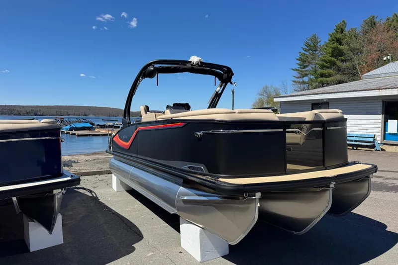 Slide: The Image of 2026 Harris Sunliner 230 Sport pontoon boat docked by a serene lakeside. - 13