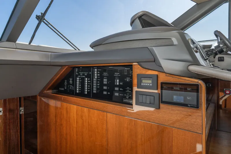 Slide: The Image of The image shows the cockpit of a Princess F55 yacht with modern instruments and wood paneling. - 52