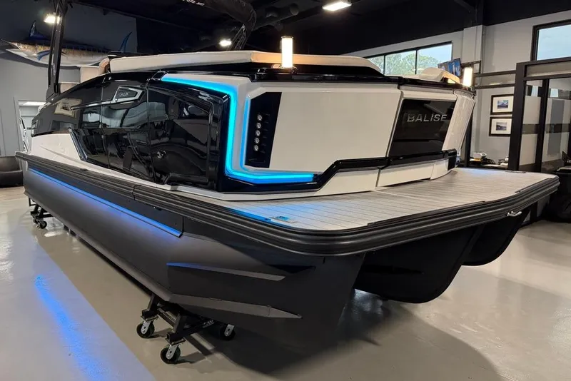 Slide: The Image of 2025 Balise Horizon 24 boat with sleek design and blue LED accents in showroom. - 23