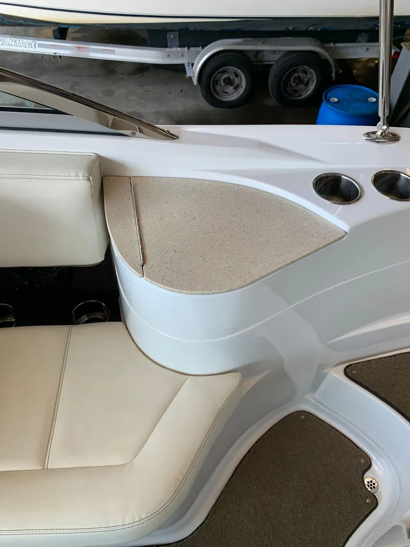 Slide: The Image of Interior of a 2015 Cobalt 243 boat with beige seating and cup holders. - 19