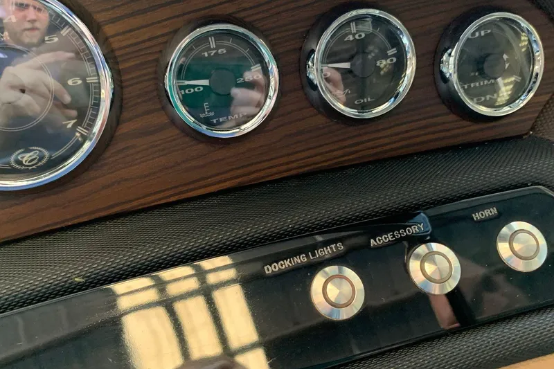 Slide: The Image of Dashboard of a 2015 Cobalt 243 boat with wood paneling and switches. - 33