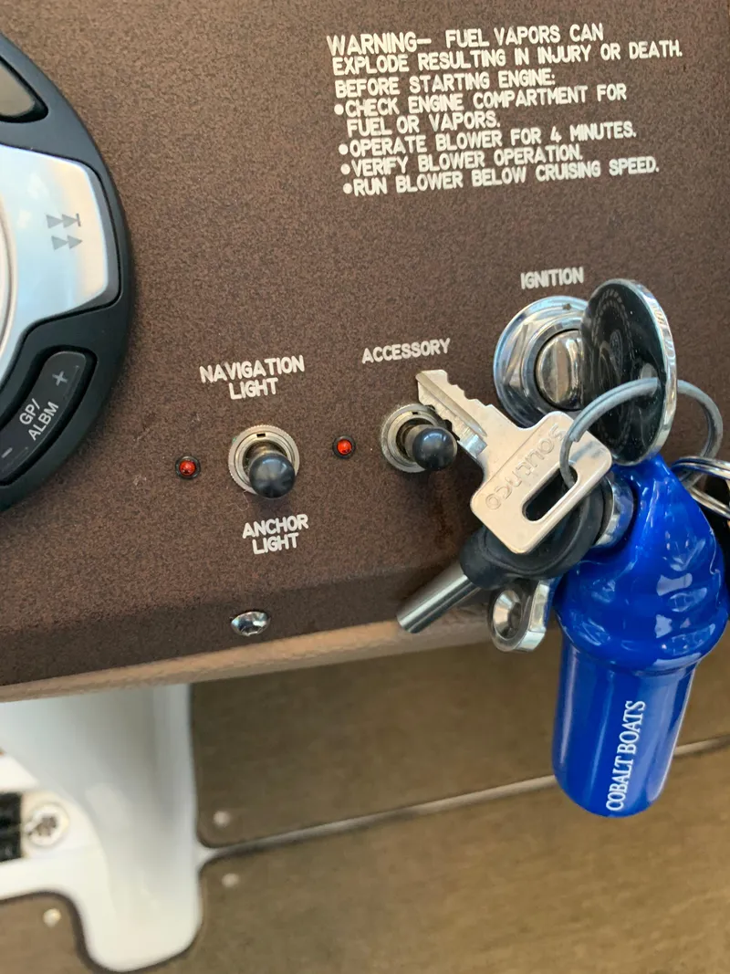 Slide: The Image of 2015 Cobalt 243 boat ignition with keys and controls. - 35