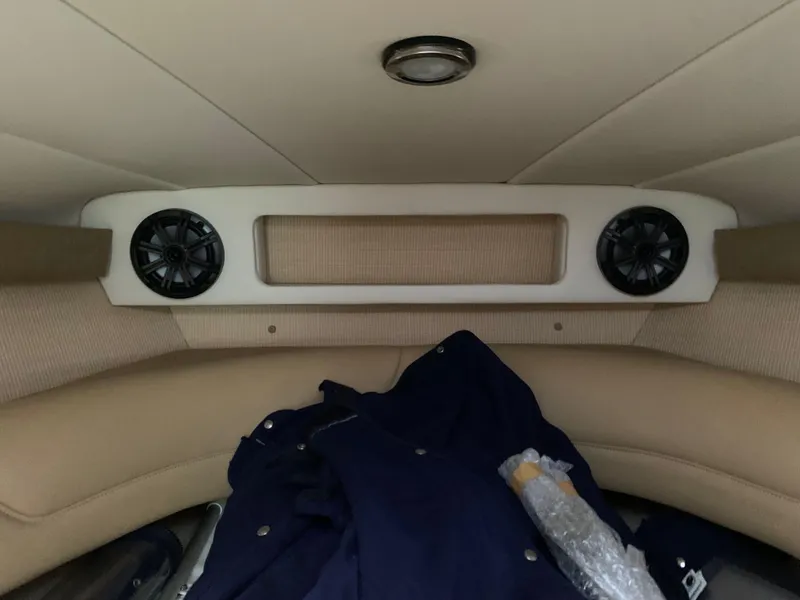 Slide: The Image of Interior of a 2015 Cobalt 243 boat, featuring speakers and seating area. - 48